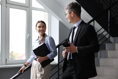 Coworkers talking while going down stairs in office