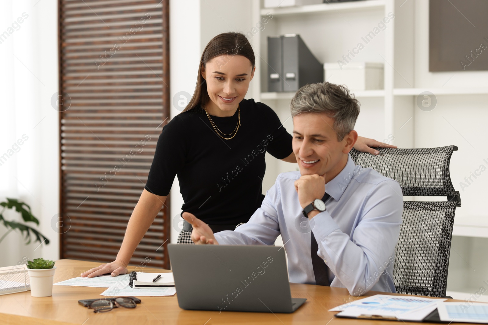 Photo of Coworkers working together at table in office