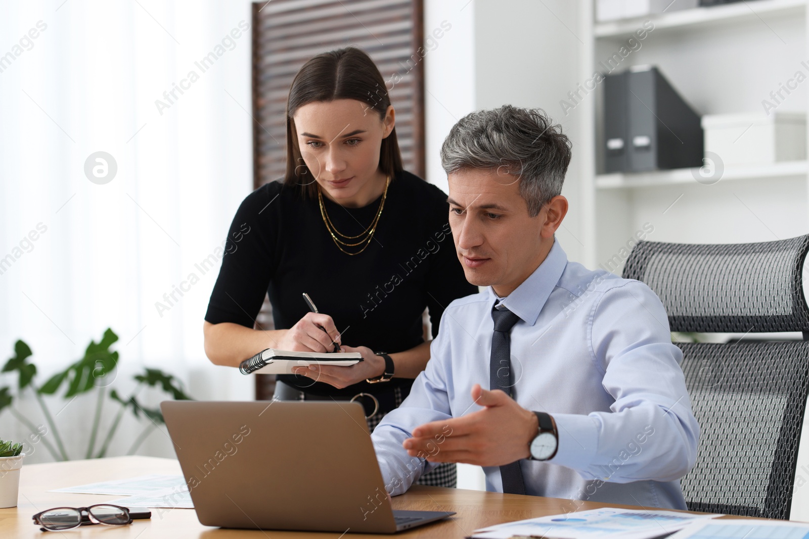 Photo of Coworkers working together at table in office