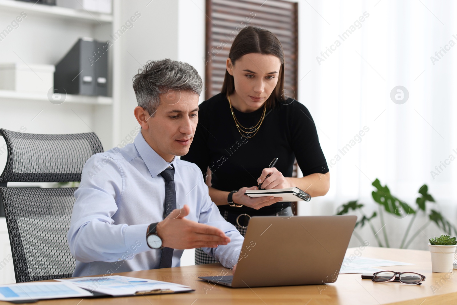 Photo of Coworkers working together at table in office