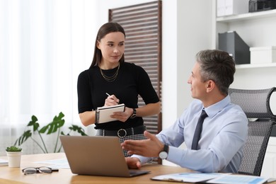 Photo of Coworkers working together at table in office