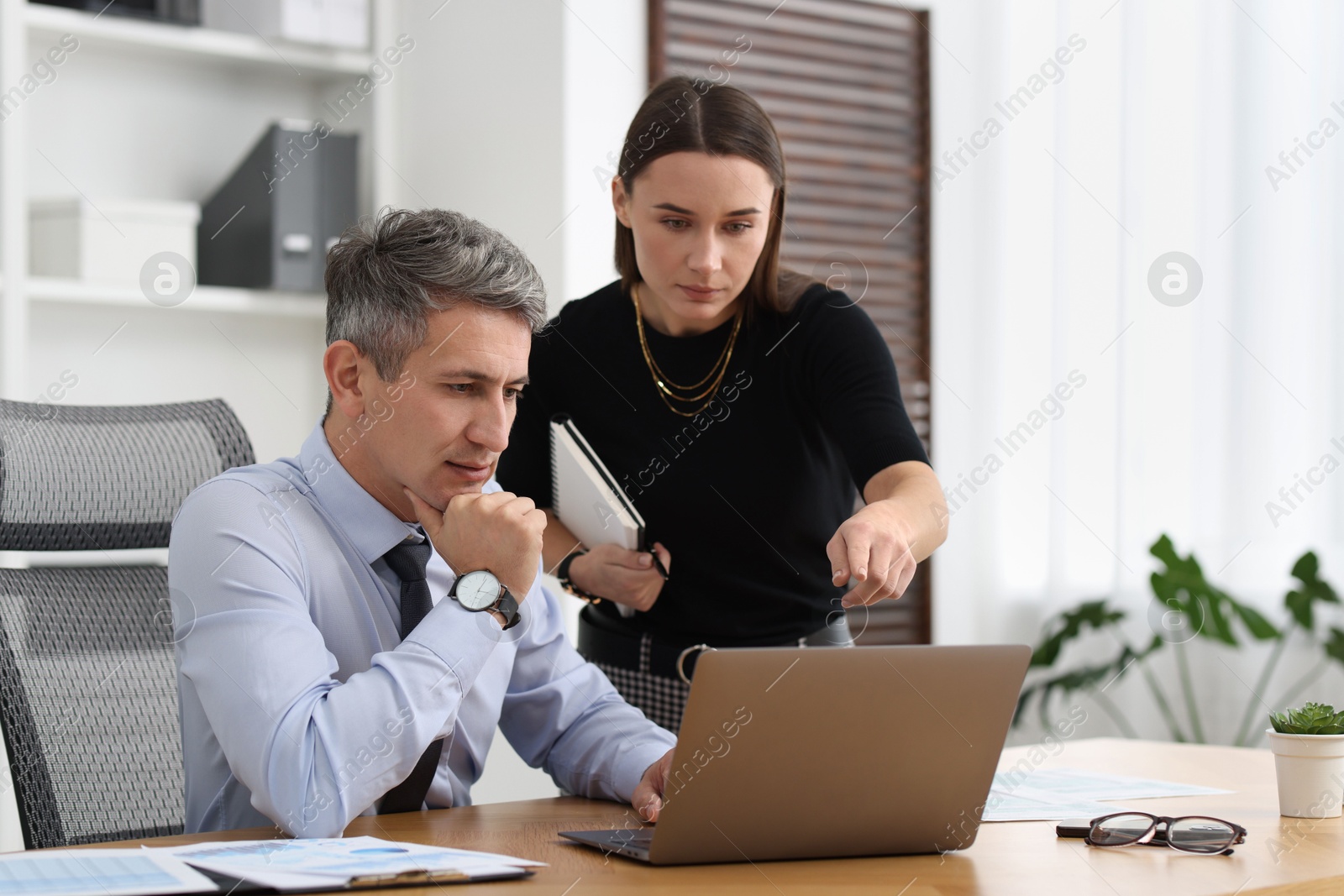 Photo of Coworkers working together at table in office