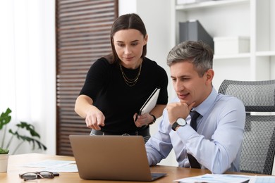 Photo of Coworkers working together at table in office