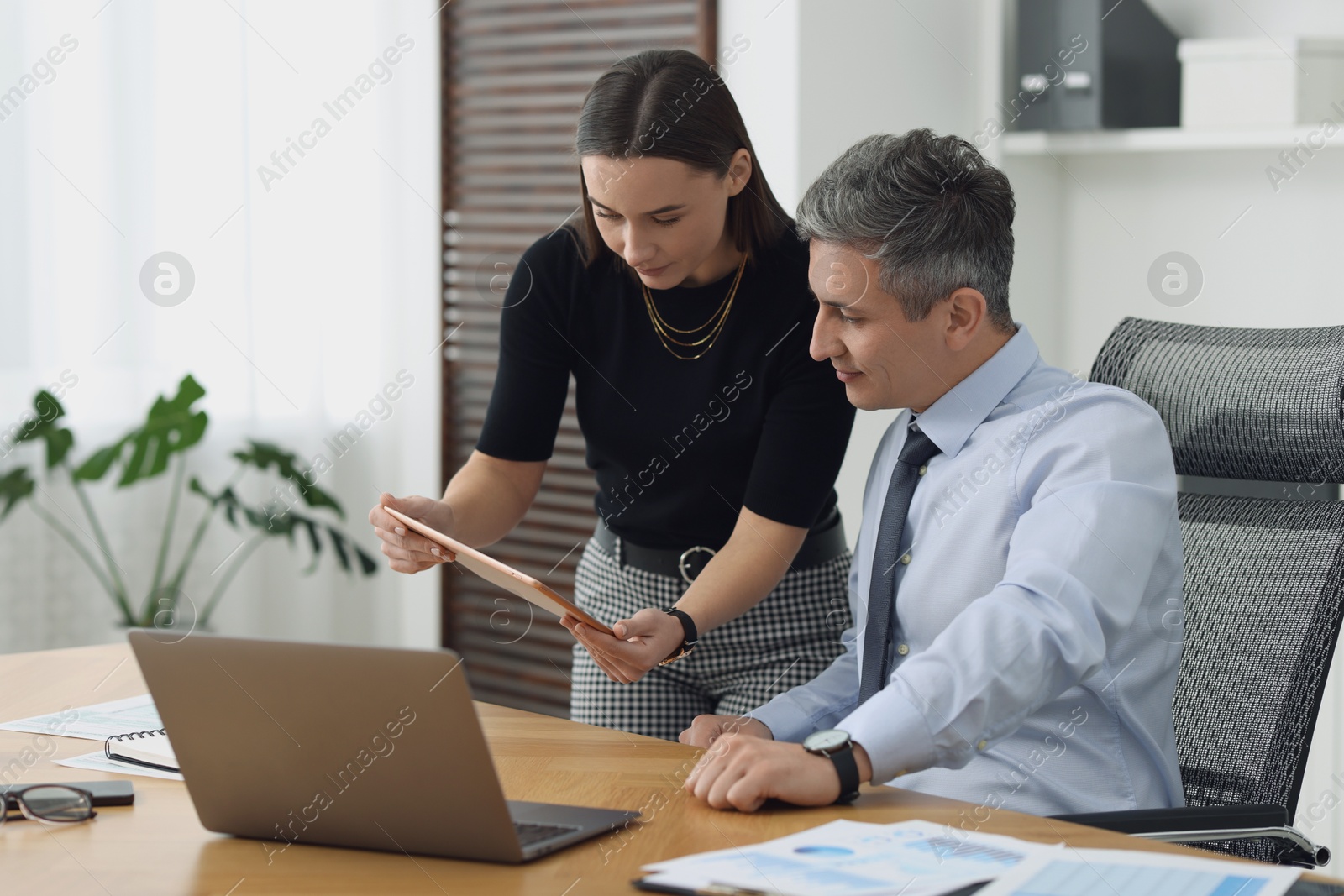 Photo of Coworkers working together at table in office