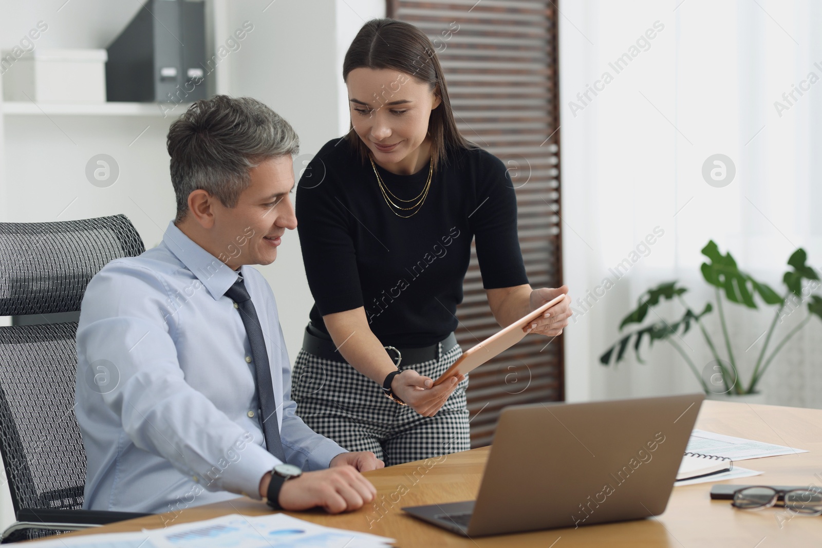 Photo of Coworkers working together at table in office