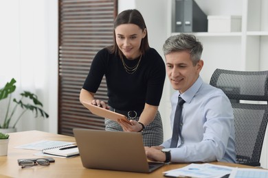 Photo of Coworkers working together at table in office