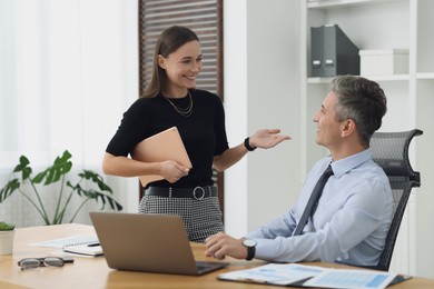 Photo of Coworkers working together at table in office