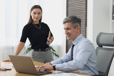 Photo of Coworkers working together at table in office