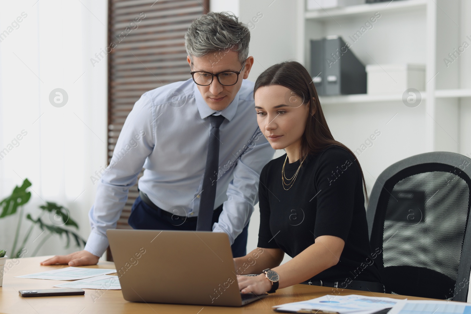 Photo of Coworkers working together at table in office