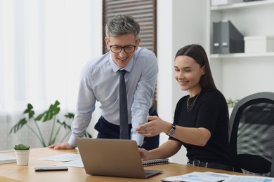 Photo of Coworkers working together at table in office