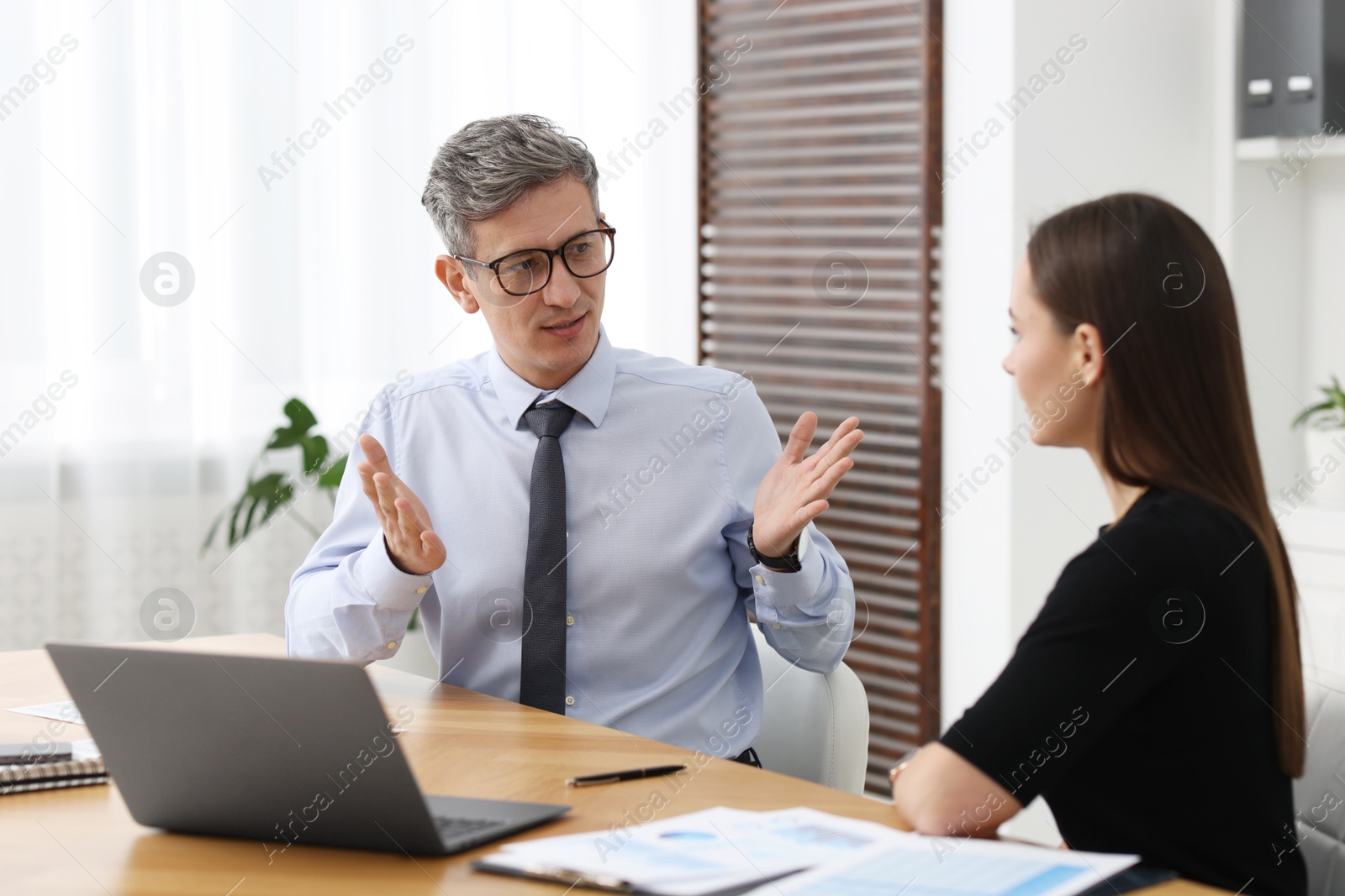 Photo of Coworkers working together at table in office