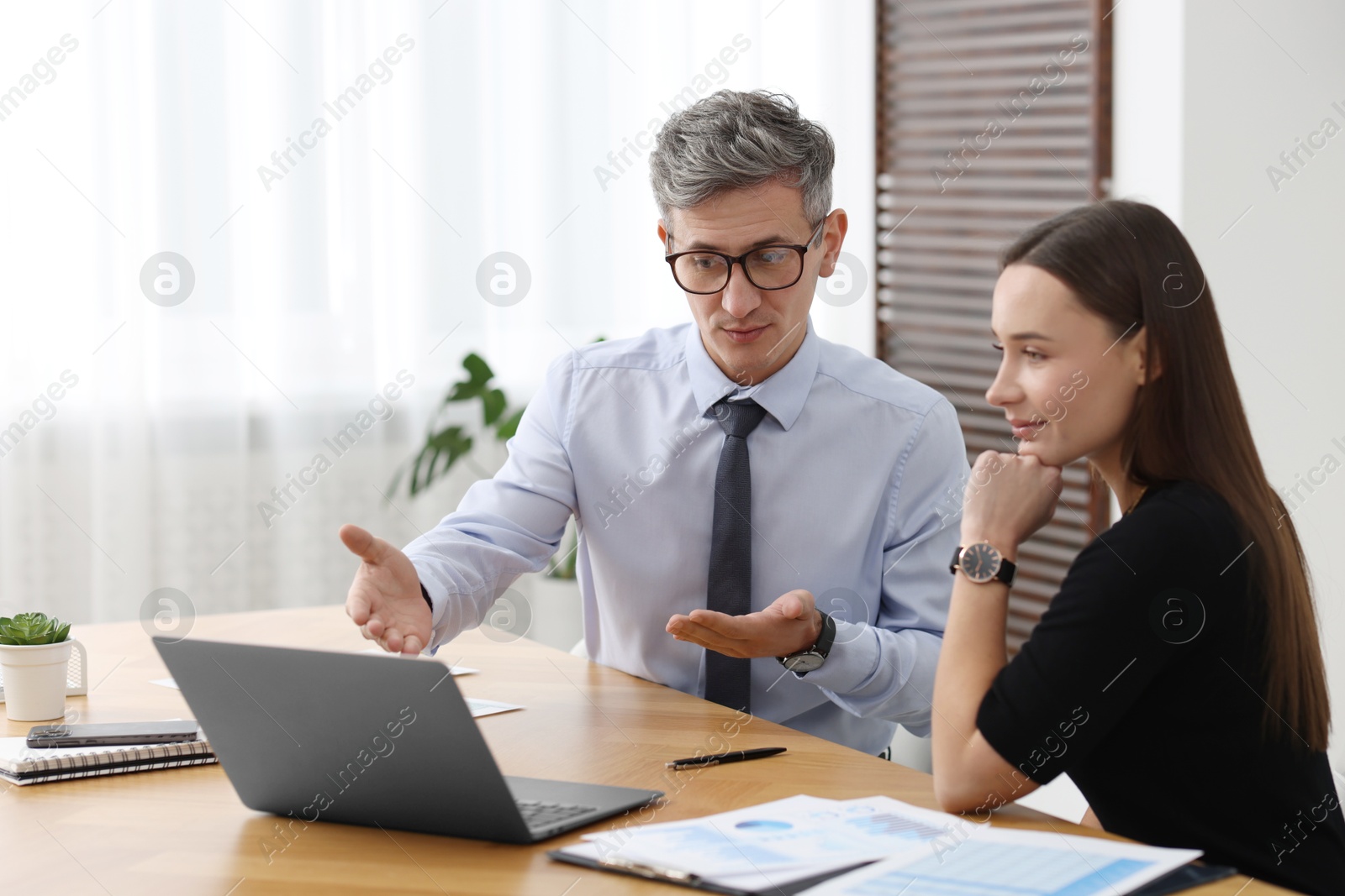 Photo of Coworkers working together at table in office