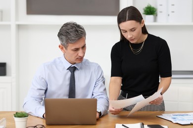 Photo of Coworkers working together at table in office