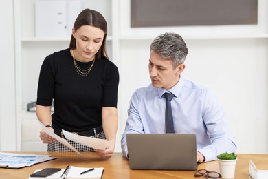 Photo of Coworkers working together at table in office