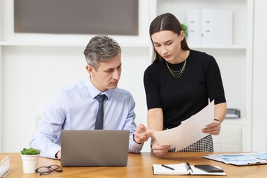 Photo of Coworkers working together at table in office