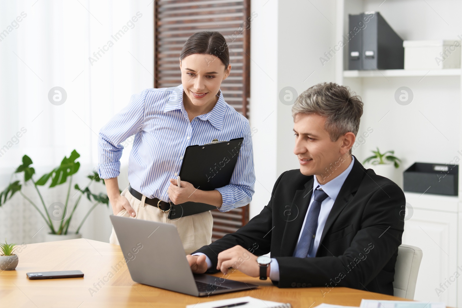 Photo of Coworkers with laptop working together in office