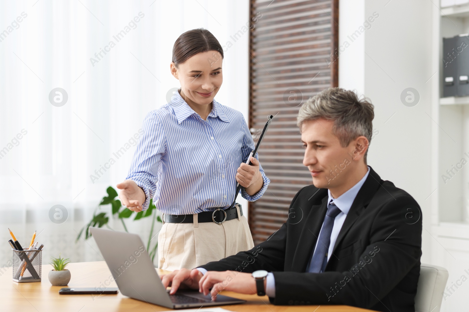 Photo of Coworkers with laptop working together in office