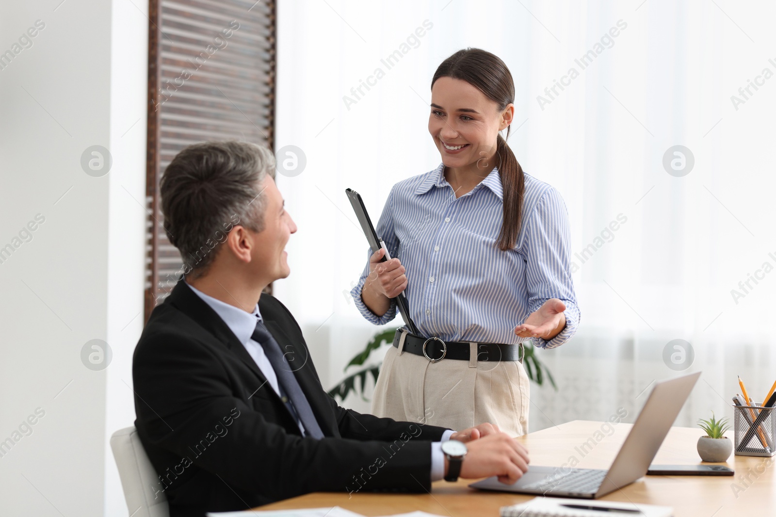 Photo of Coworkers with laptop working together in office