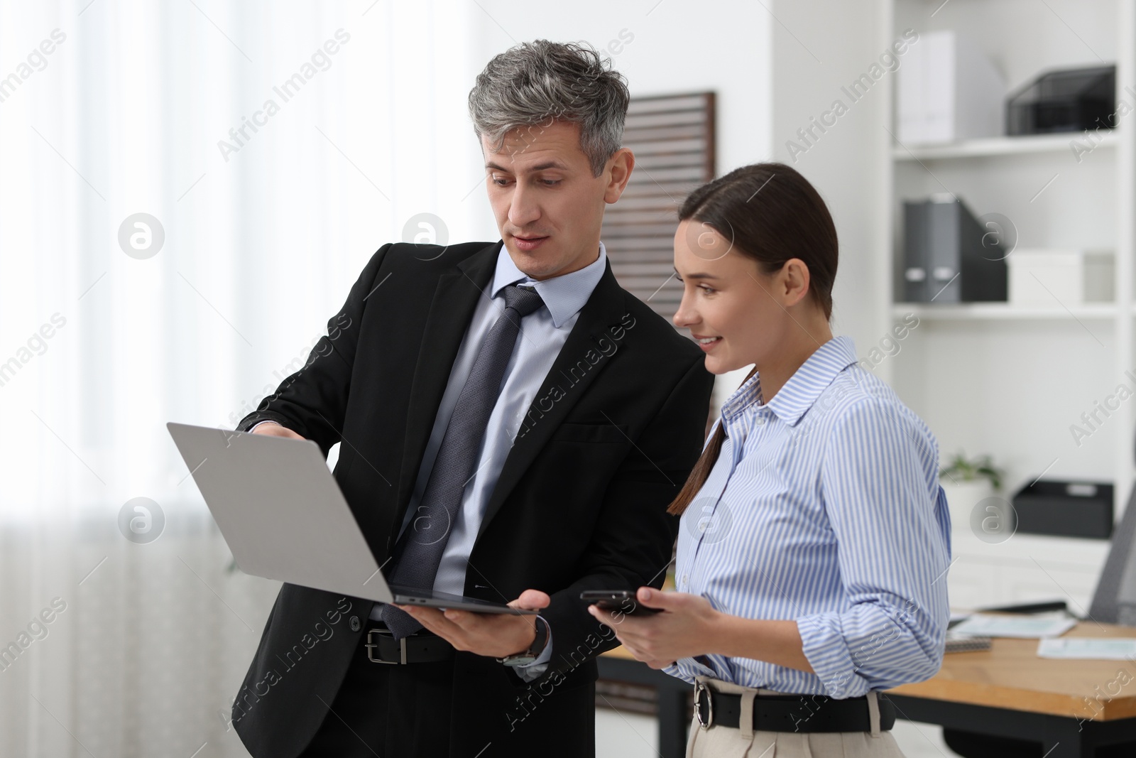 Photo of Coworkers with laptop working together in office