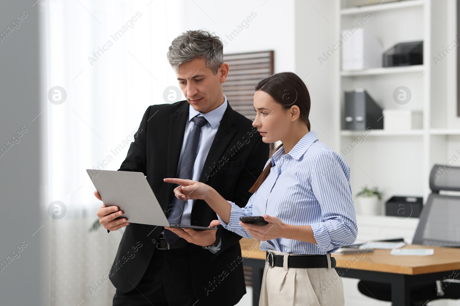 Photo of Coworkers with laptop working together in office