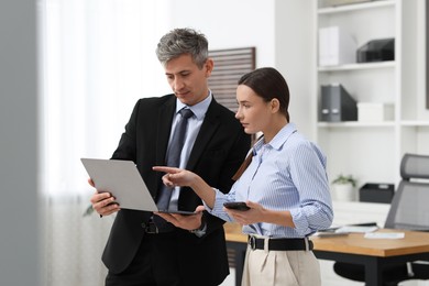 Photo of Coworkers with laptop working together in office