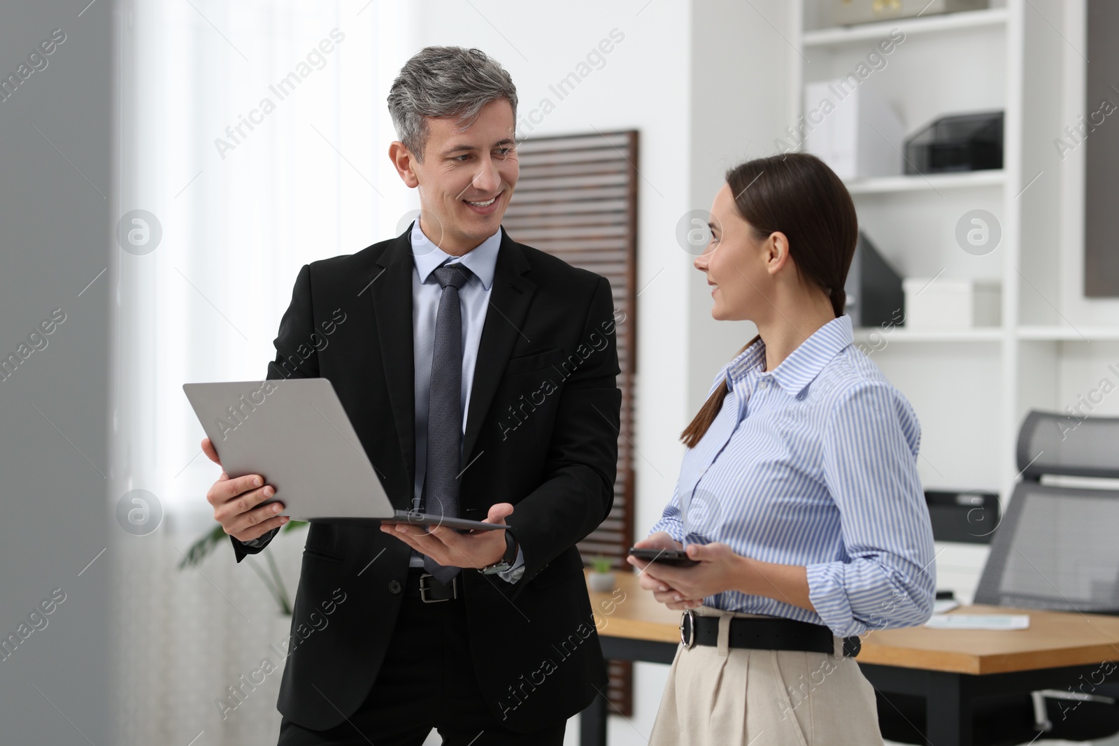 Photo of Coworkers with laptop working together in office