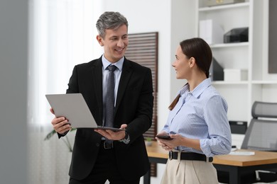 Photo of Coworkers with laptop working together in office