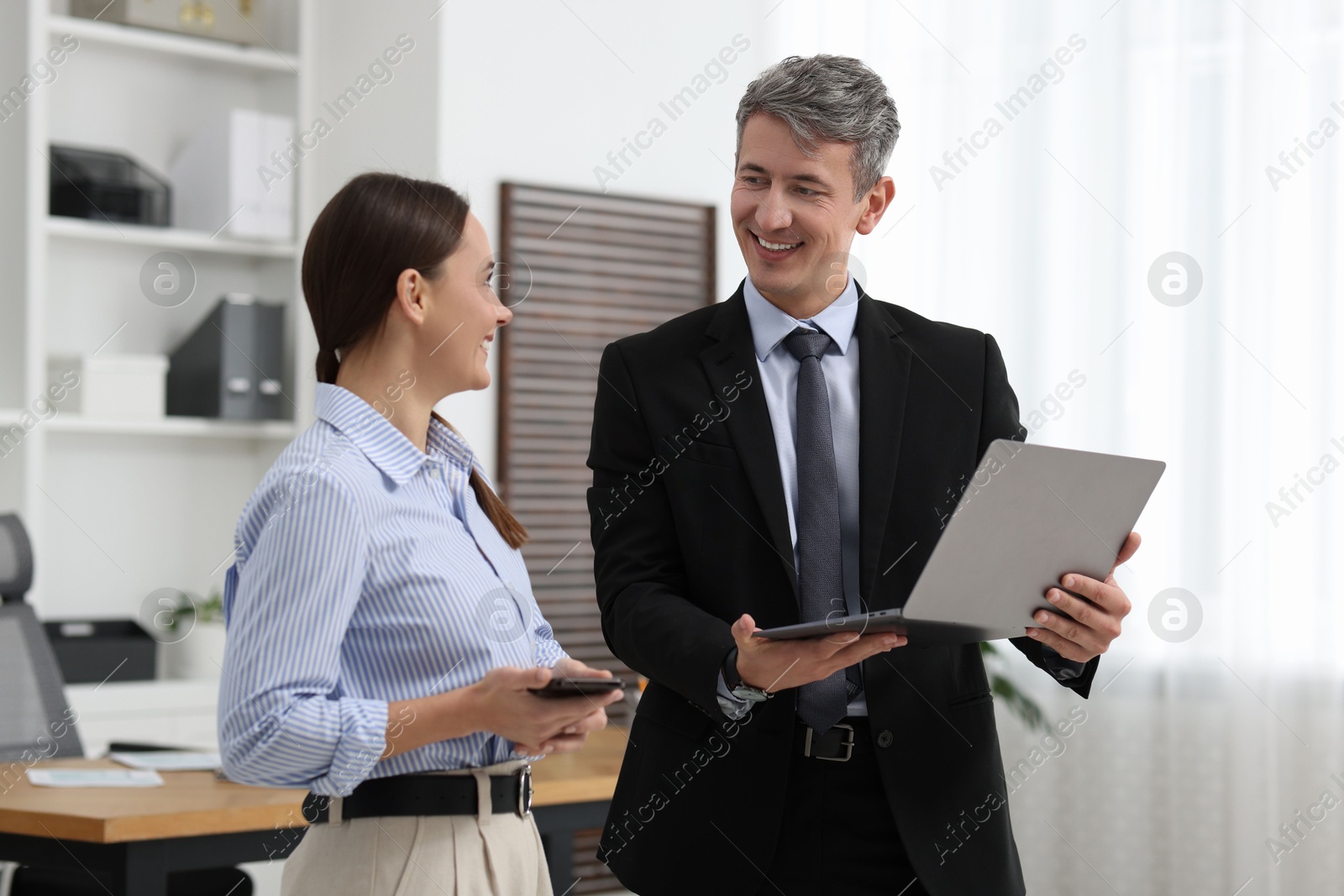 Photo of Coworkers with laptop working together in office