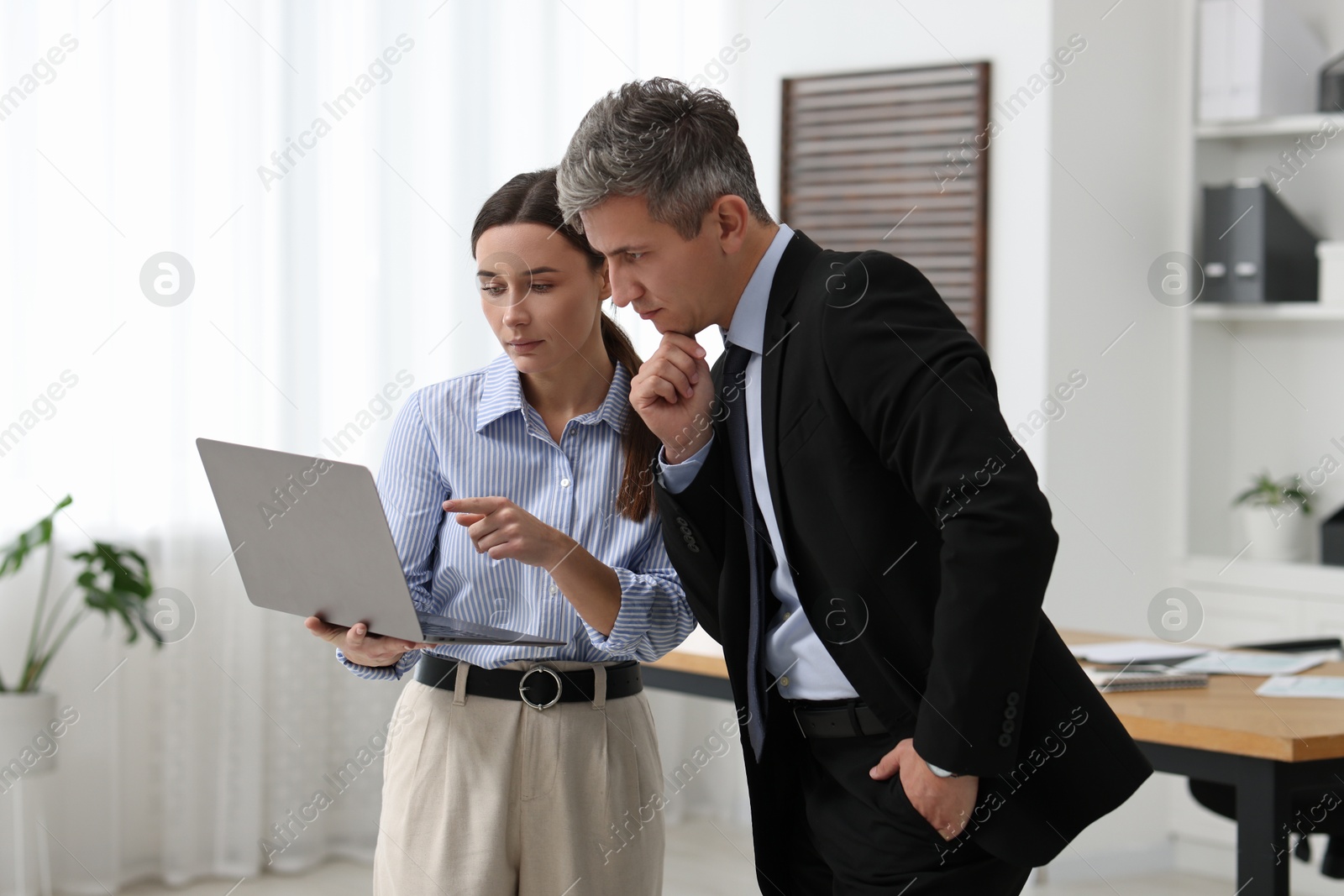 Photo of Coworkers with laptop working together in office