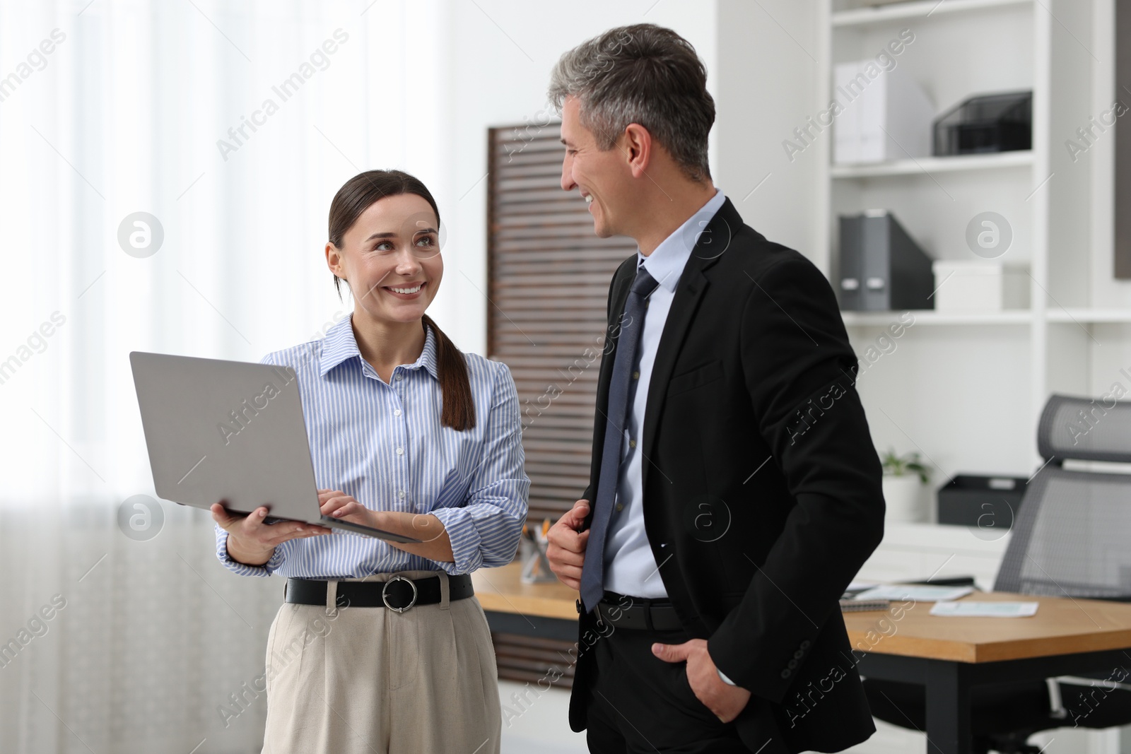 Photo of Coworkers with laptop working together in office