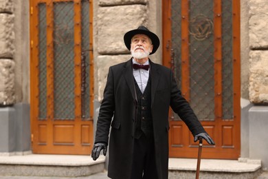 Photo of Elegant senior man with walking cane on city street