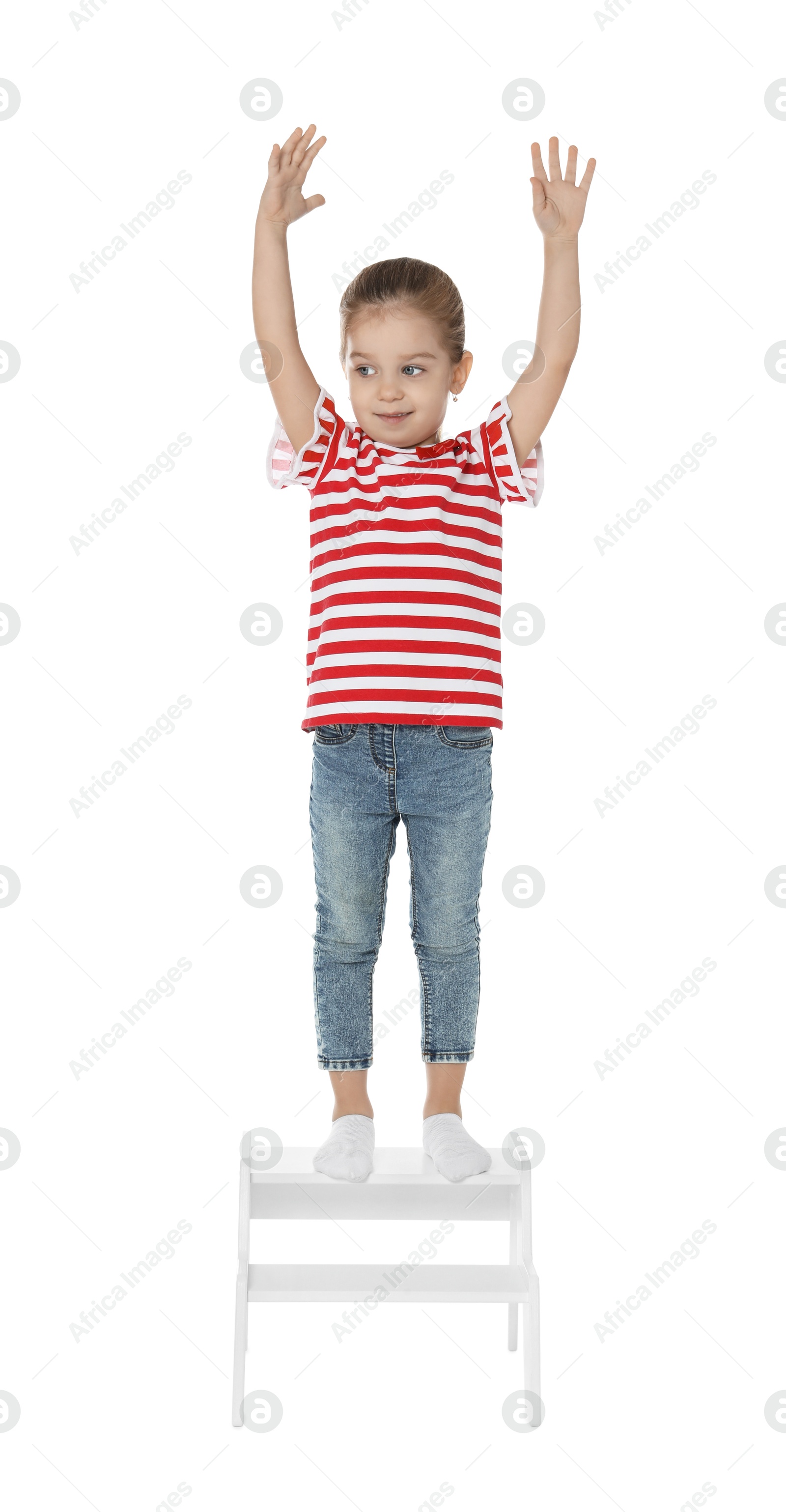 Photo of Little girl standing on step stool against white background