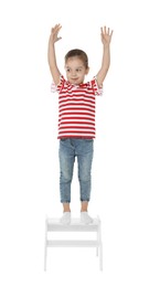 Photo of Little girl standing on step stool against white background