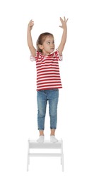 Photo of Little girl standing on step stool against white background