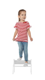 Photo of Little girl standing on step stool against white background