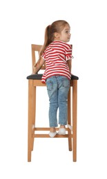 Little girl standing on stool against white background