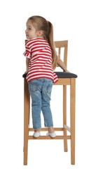 Little girl standing on stool against white background