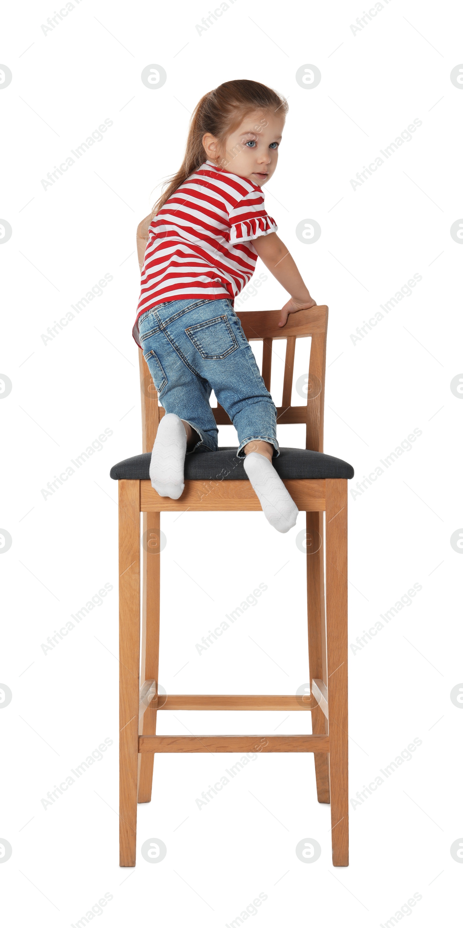 Photo of Little girl sitting on stool against white background