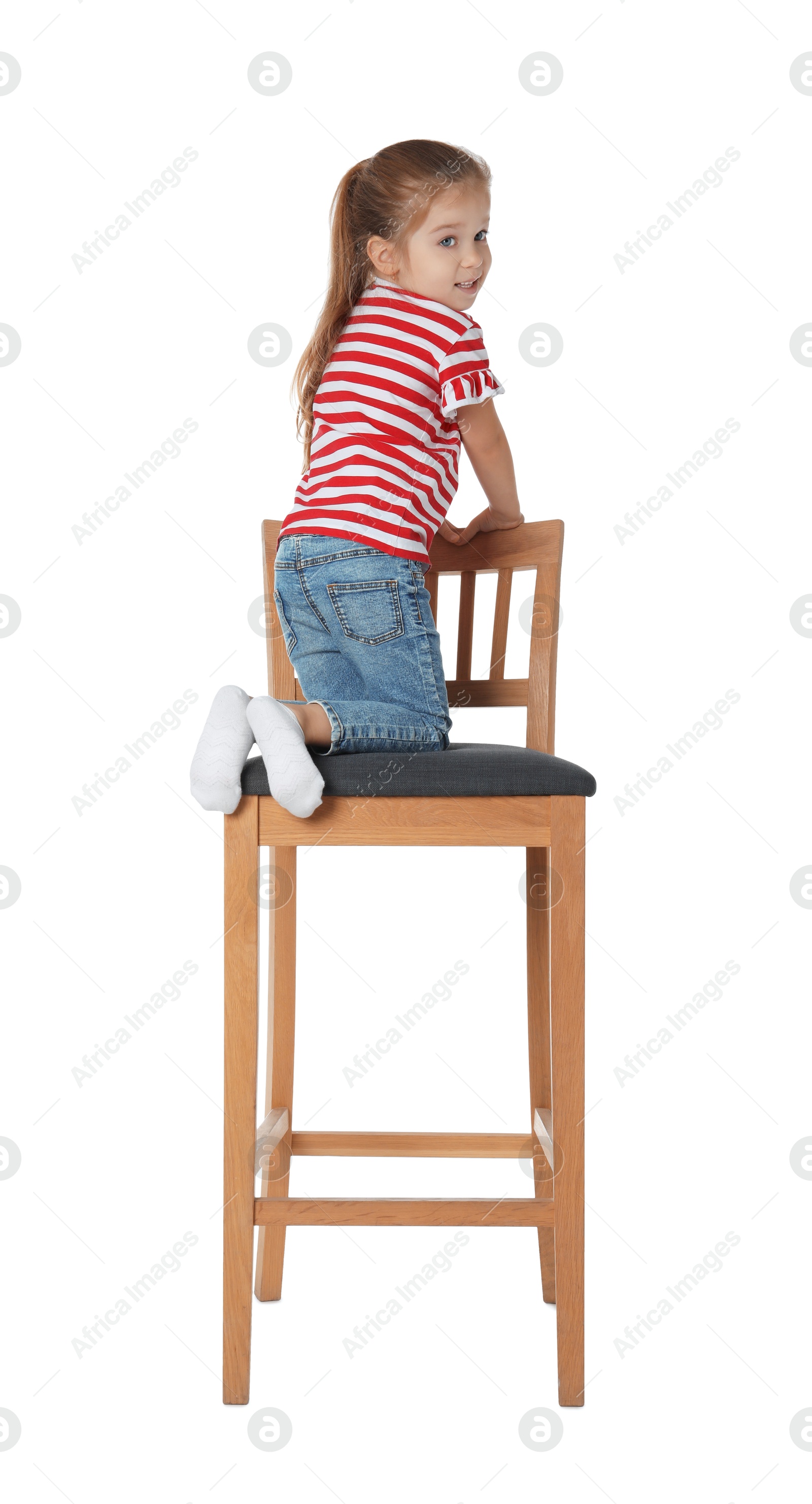 Photo of Little girl sitting on stool against white background