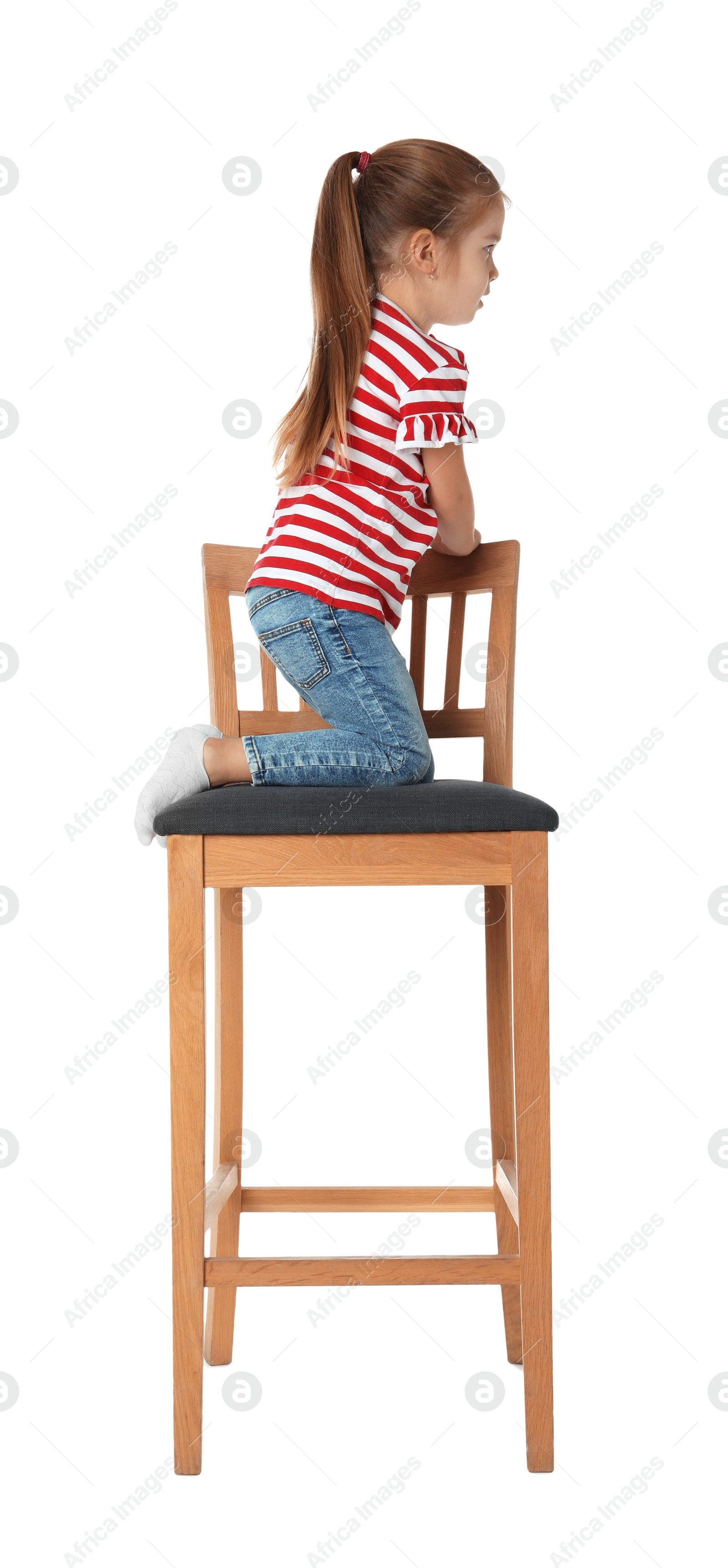 Photo of Little girl sitting on stool against white background