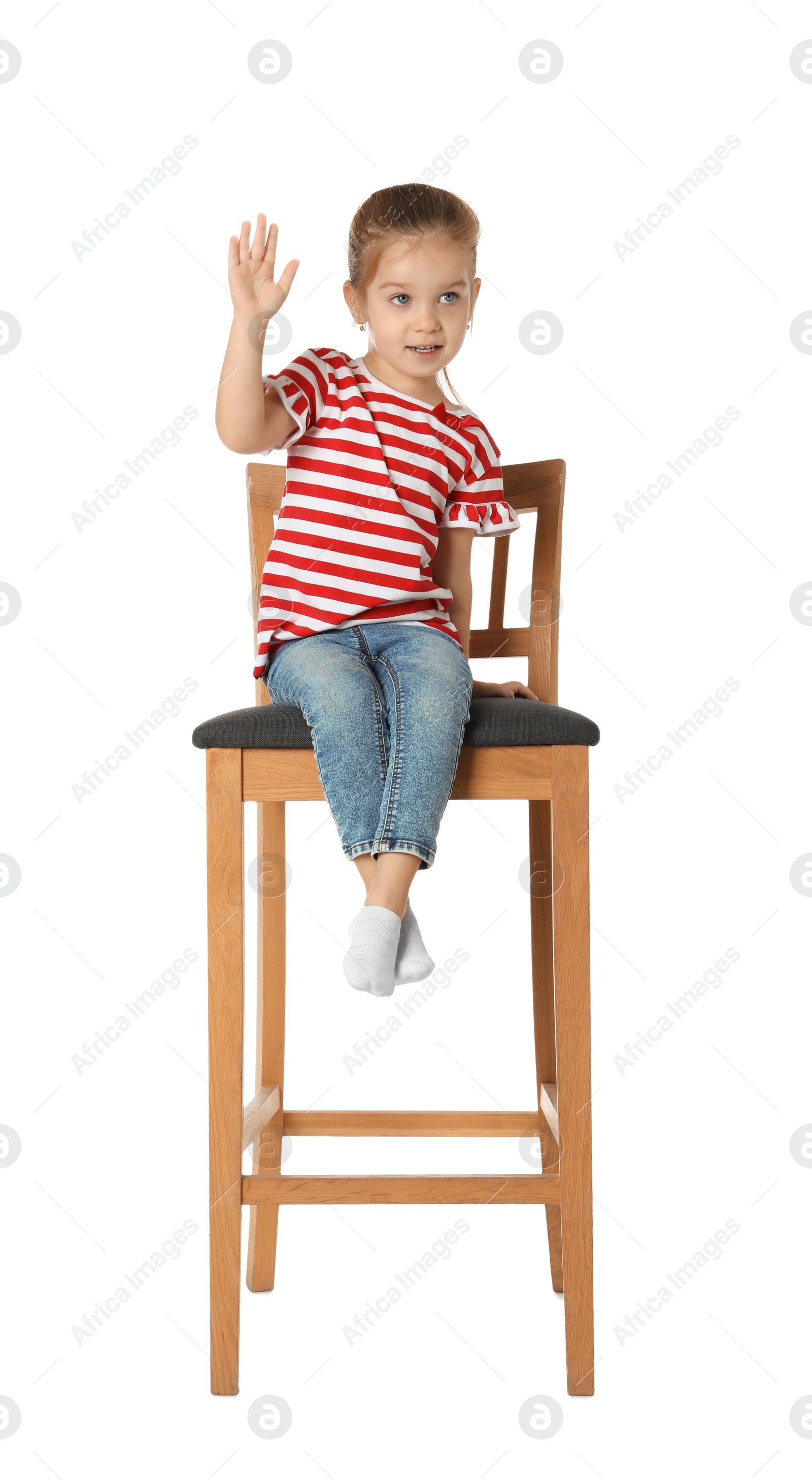 Photo of Little girl sitting on stool against white background