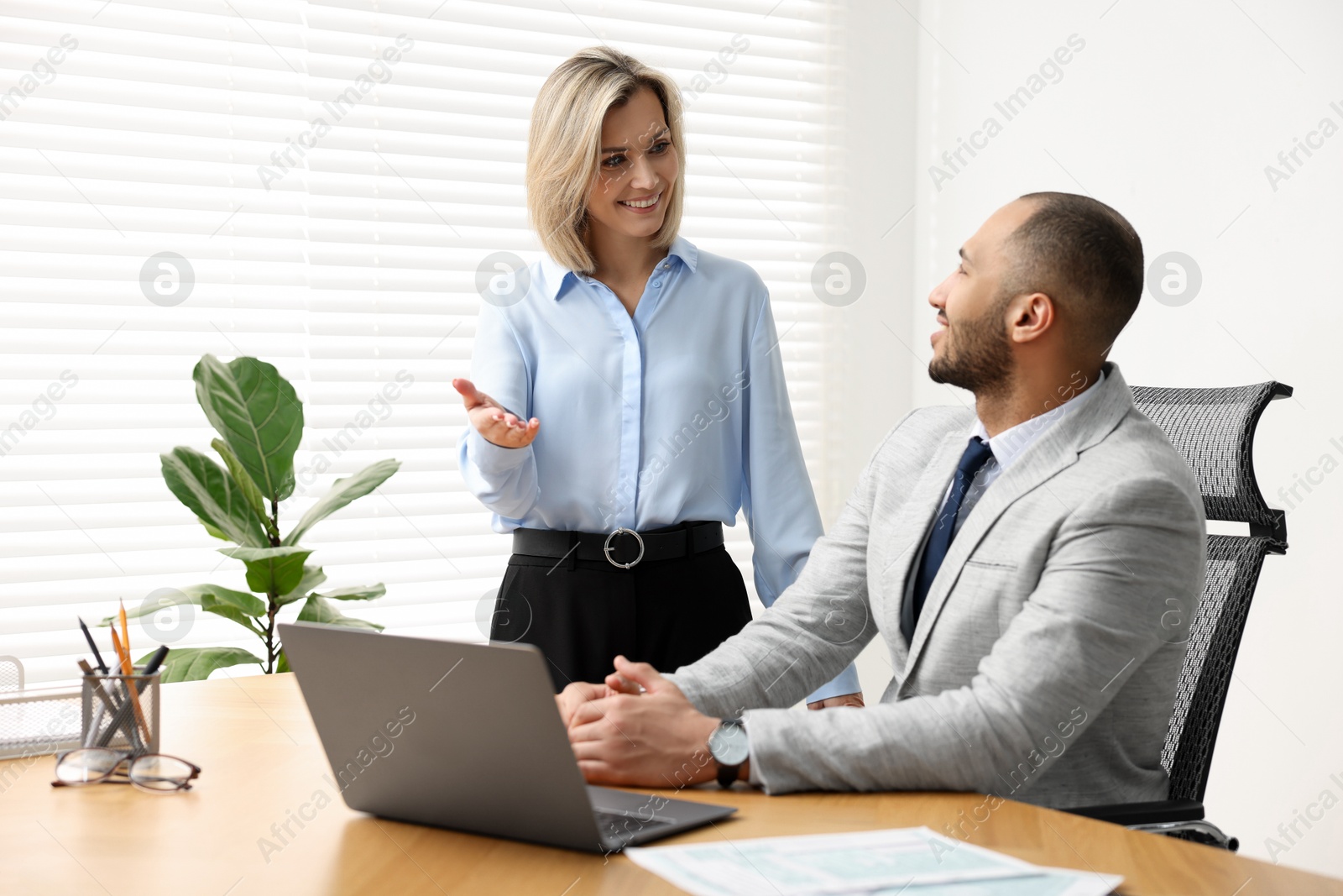 Photo of Coworkers with laptop working together in office