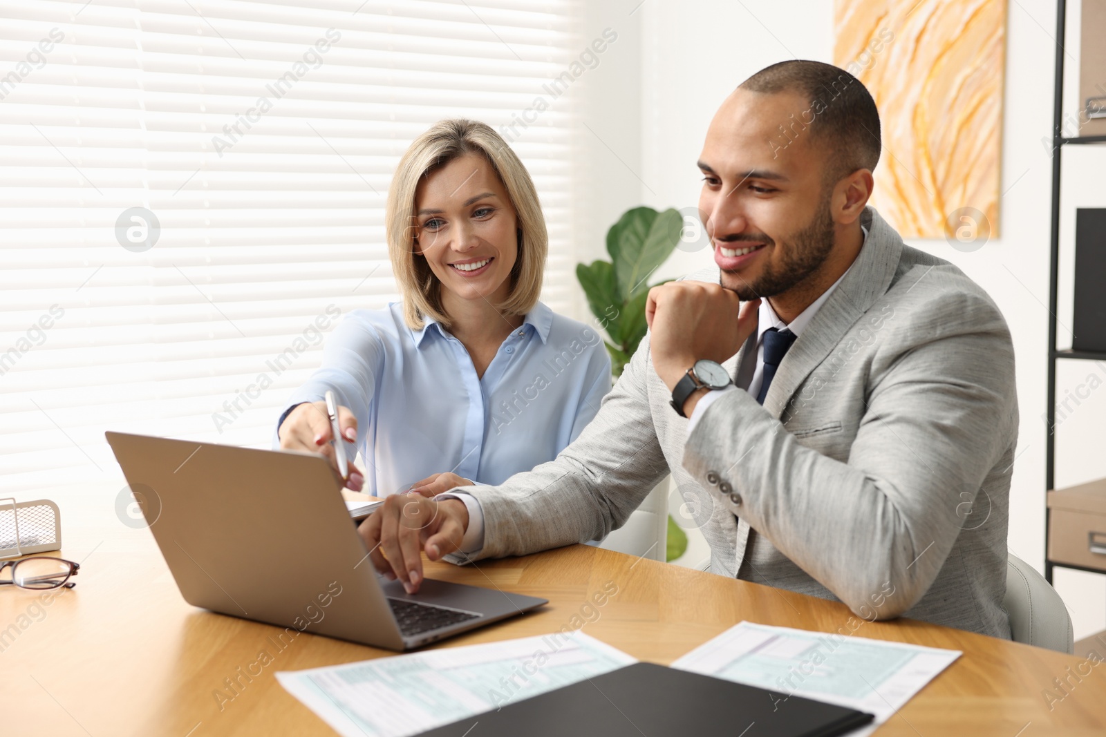 Photo of Coworkers with laptop working together in office