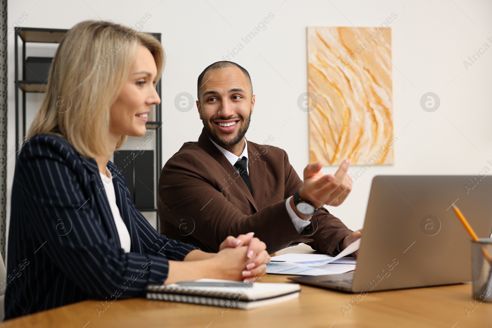 Photo of Coworkers working together at table in office