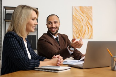 Coworkers working together at table in office