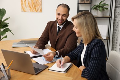 Photo of Coworkers working together at table in office