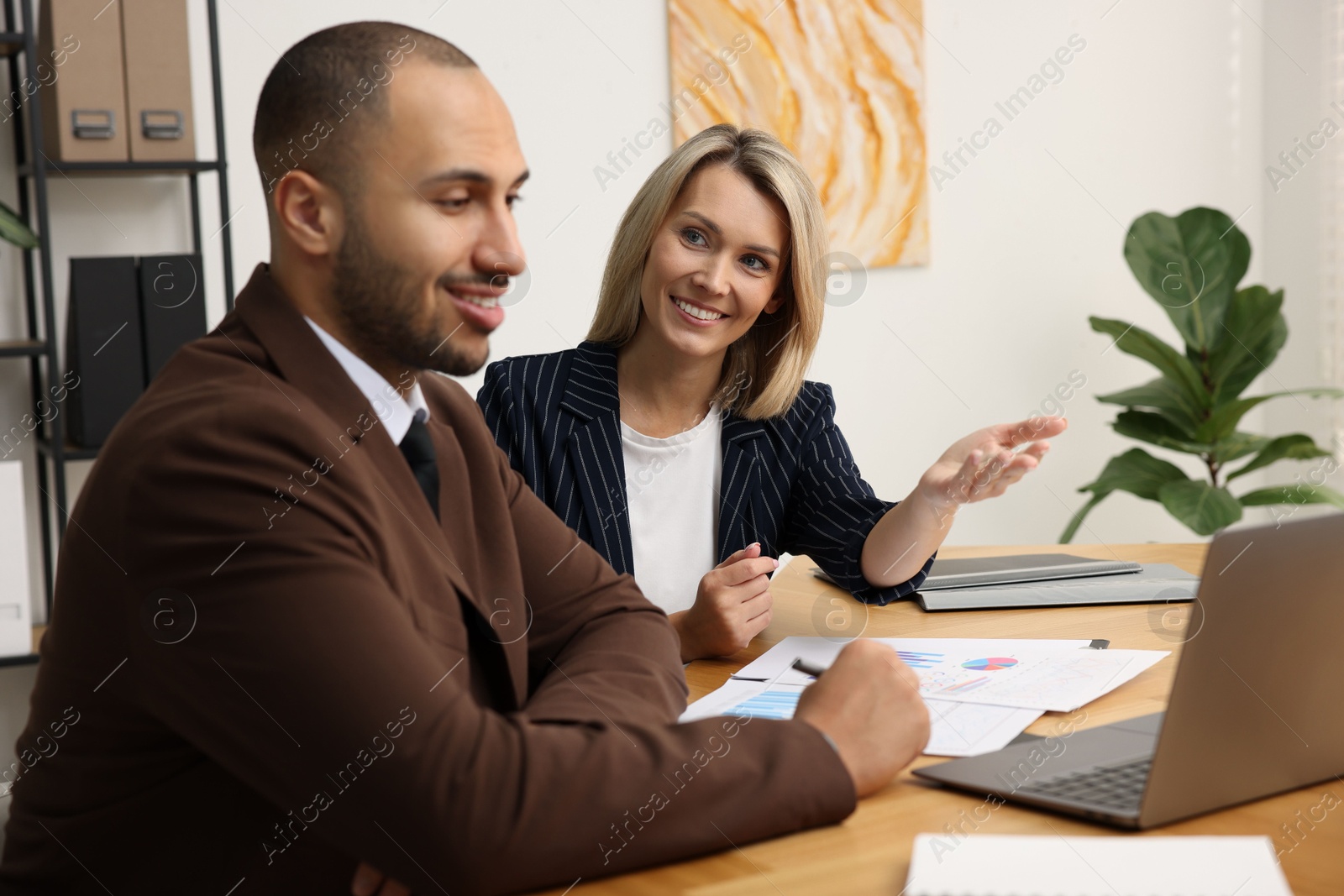 Photo of Coworkers with laptop working together in office