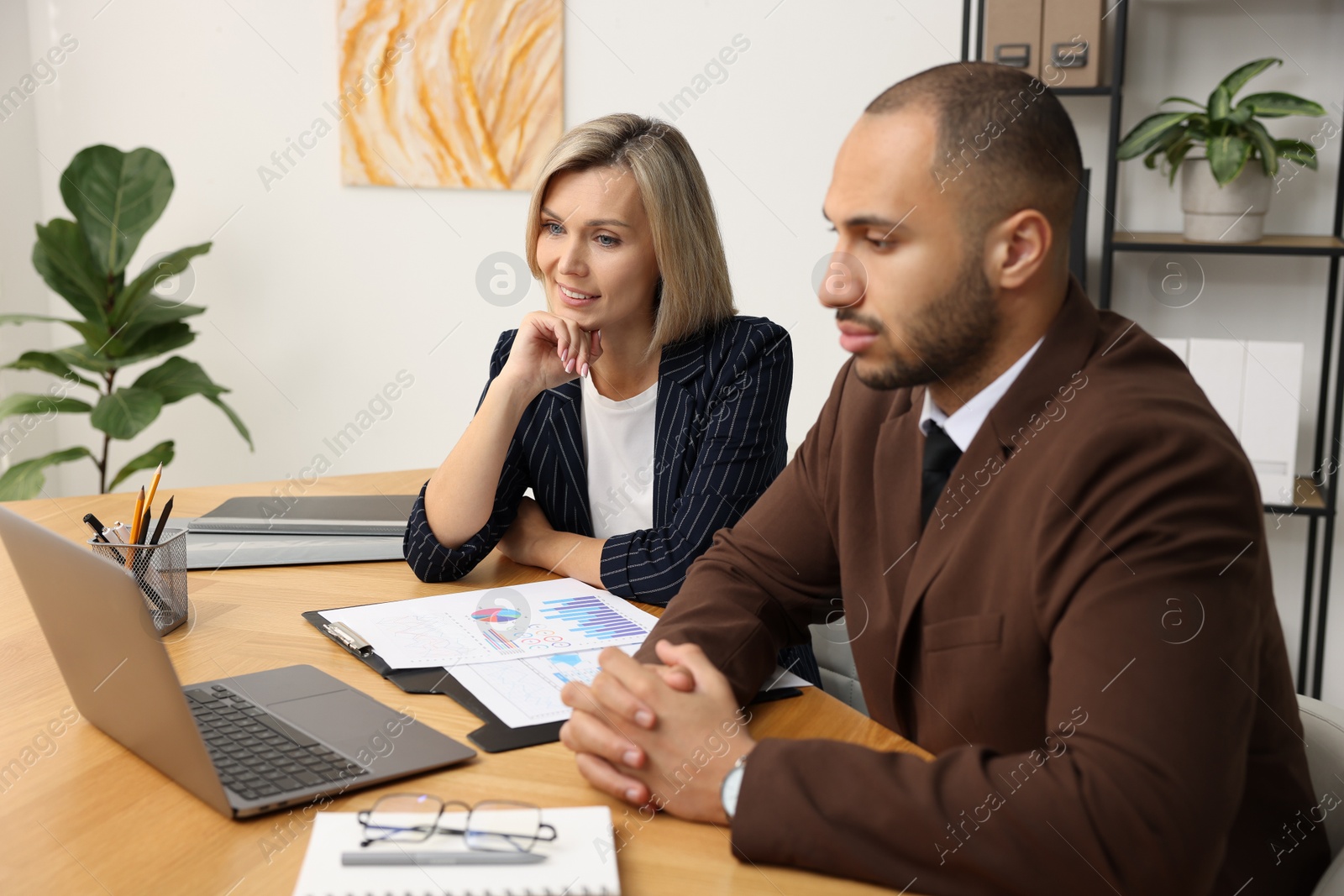 Photo of Coworkers with laptop working together in office