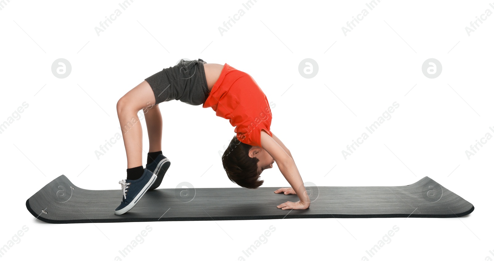 Photo of Boy exercising on fitness mat against white background. Sport activity