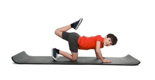 Photo of Boy exercising on fitness mat against white background. Sport activity